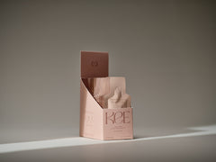 A pink KEE box with Liquid Marine Collagen Sachet - Mango Sorbet stands on a neutral background in soft lighting.